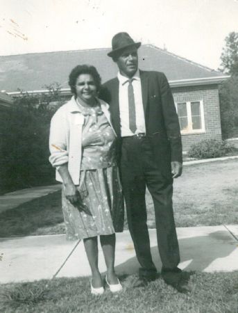 Lambert and May McBride standing on a footpath, their house can be seen in the background of the photo. 