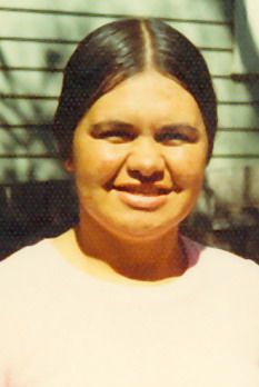 Josie Briggs in full sunlight with the wall of a house in the background.