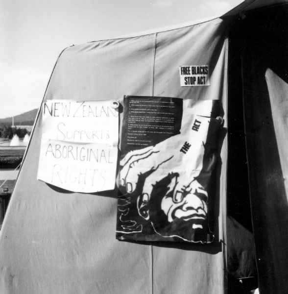 This tent carries a poster which offers New Zealand support. Another message shows the Queensland Aborigines Act as a hand crushing an Aboriginal Queenslander.